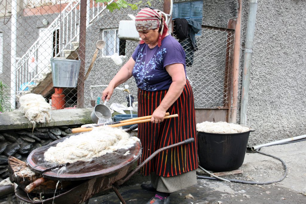 Lokale vrouw bewerkt wol in Georgië