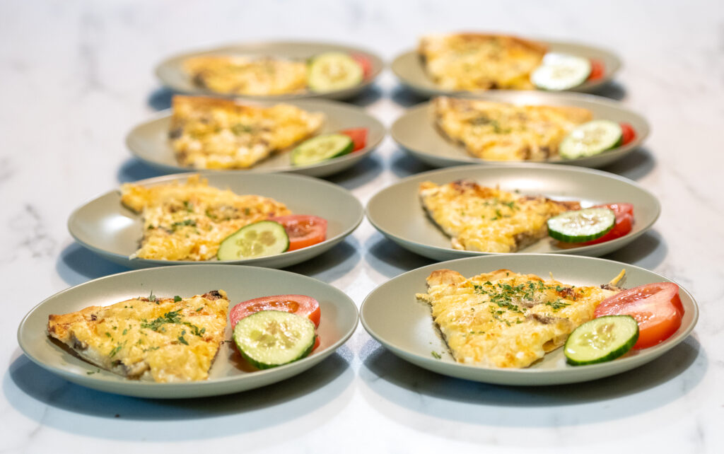 Acht bordjes met een omelet op een tafel