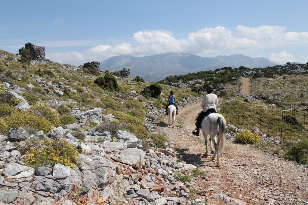 Twee ruiters aan het paardrijden over de heuvels van Kreta