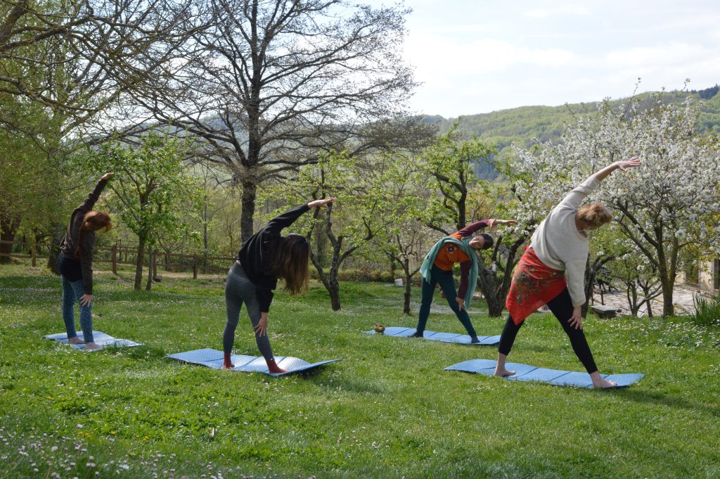 Groep vrouwen doet yoga op vakantie in een tuin in Italïe
