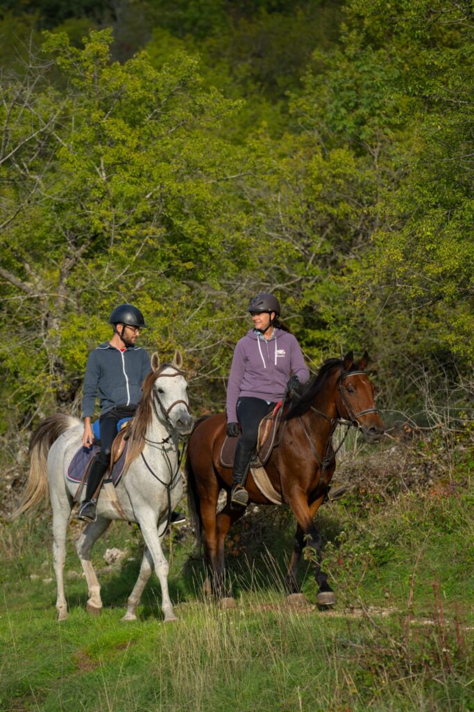 Twee ruiters en paarden op een buitenrit in Dalmatië.