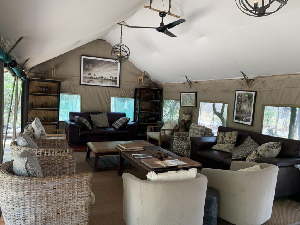 Gezamenlijke tent met banken, stoelen en een tafel op safari in Botswana