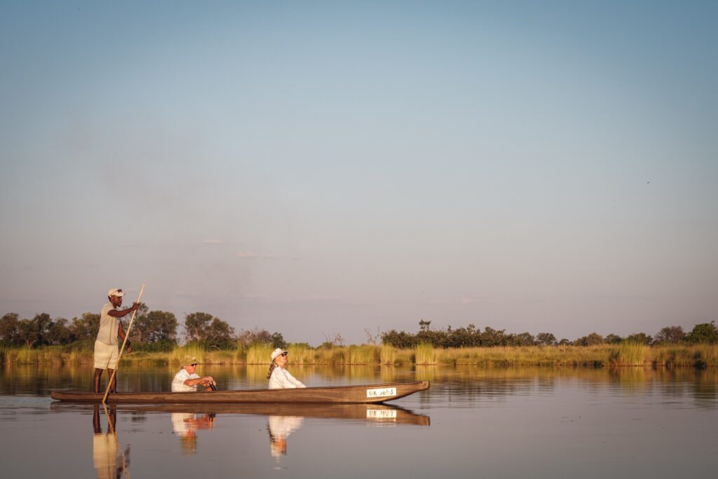 Gasten op safari in een traditionele kano in Botswana