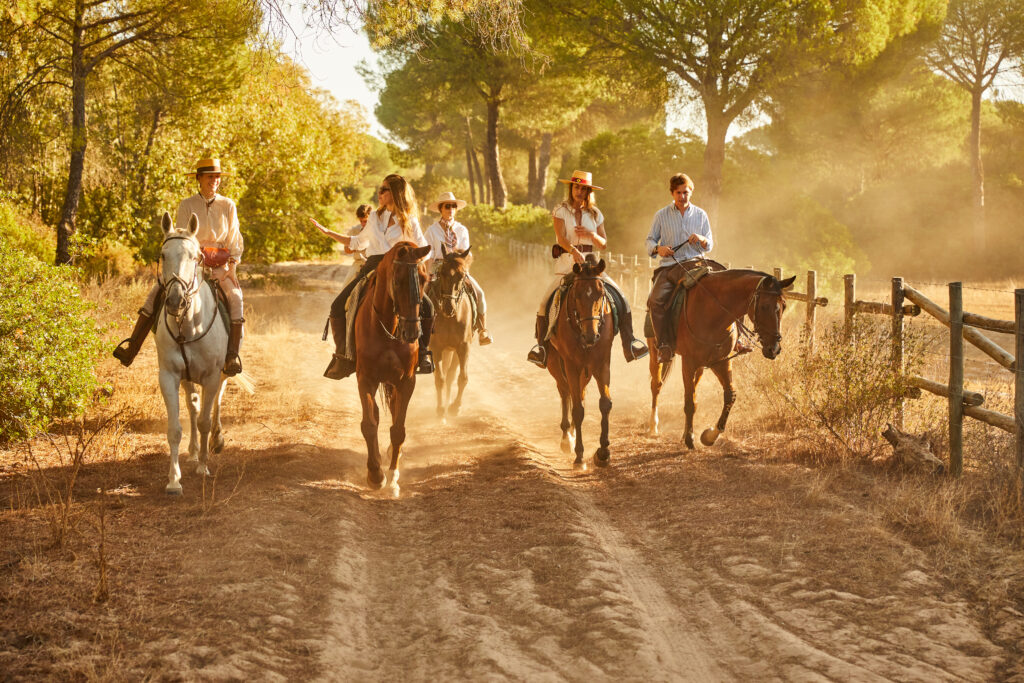 Groep ruiters en paarden tijdens een buitenrit in Spanje