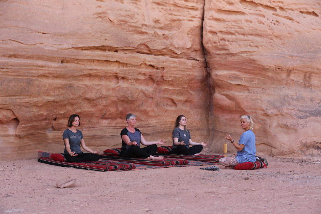 Vrouwen doen yoga poses in de woestijn in Jordanië