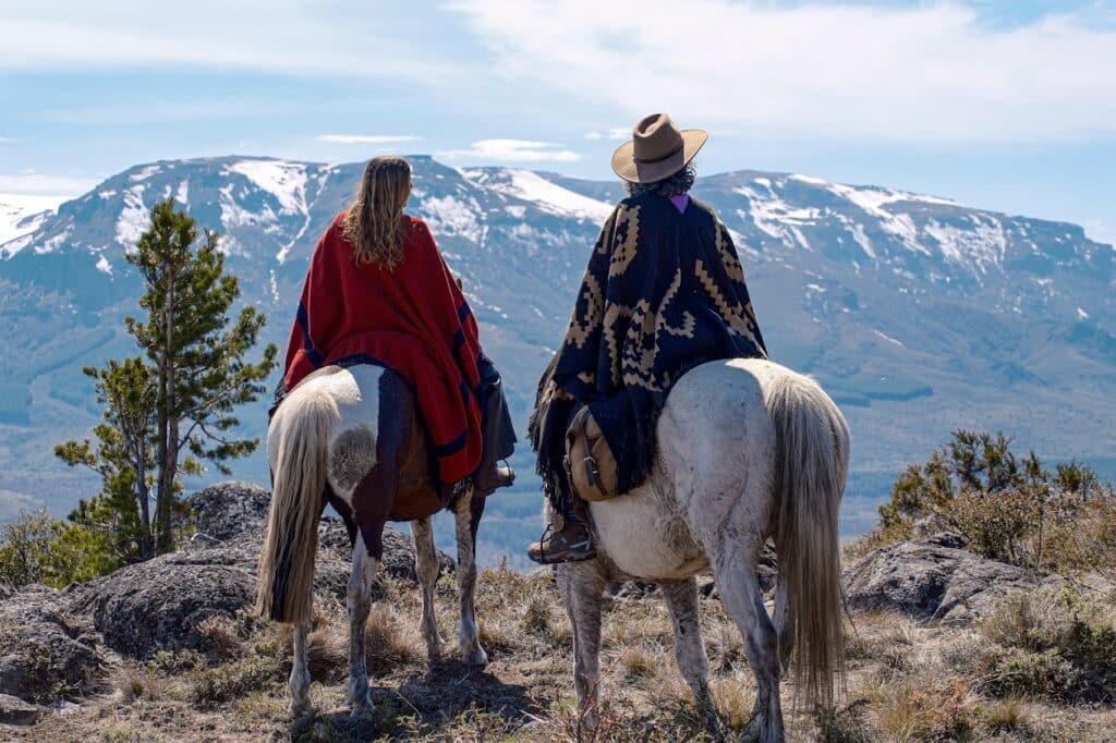 Ruiters en paarden kijken uit over de bergen in Patagonië Argentinië