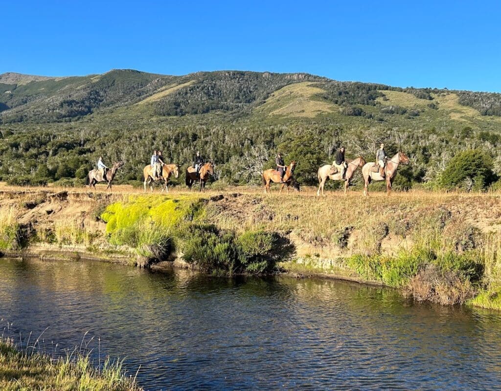 Groep ruiters en paarden bij een rivier in Patagonië Argentinië