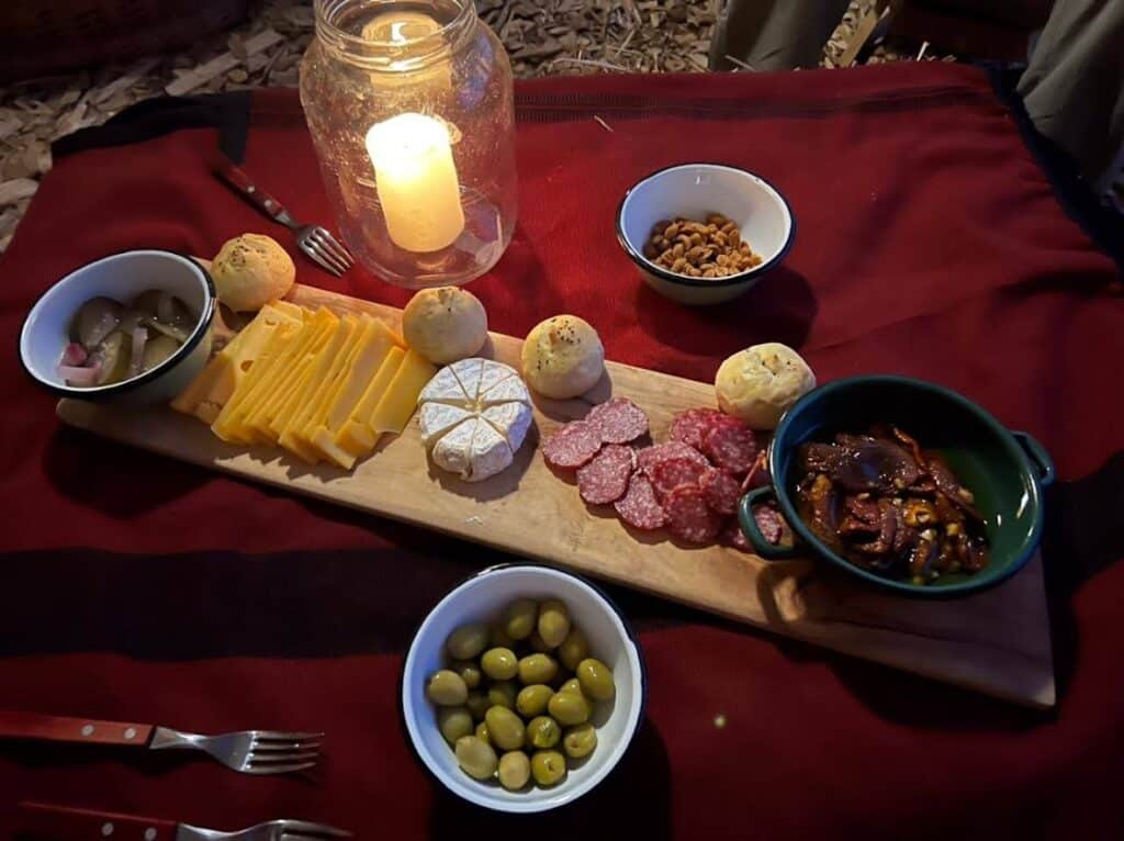 Plankje met verschillende soorten kazen, vlees, nootjes en olijven tijdens een paardrijvakantie in Patagonië Argentinië.
