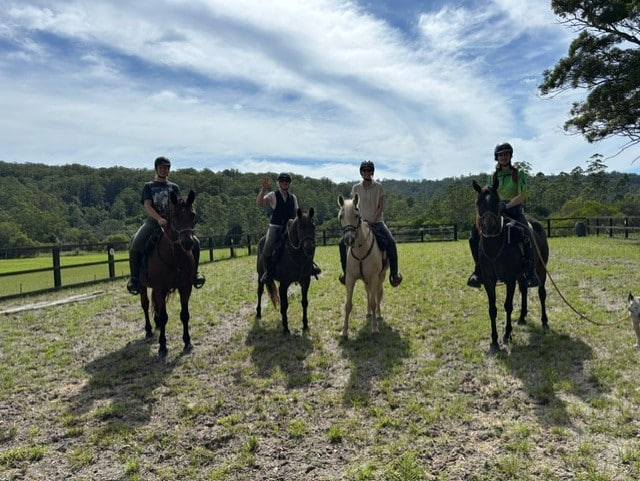 Groep ruiters en paarden in een veld tijdens een paardrijvakantie in Australië