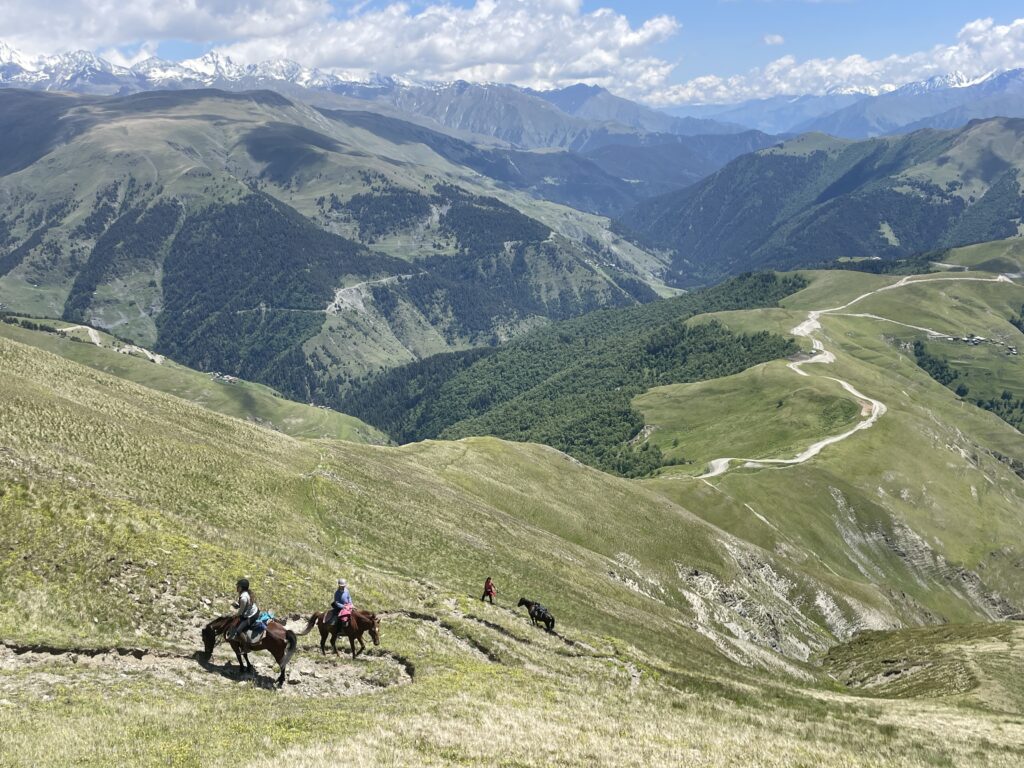 Ruiters en paarden trekken over een bergpad tijdens een vakantie in Georgië.