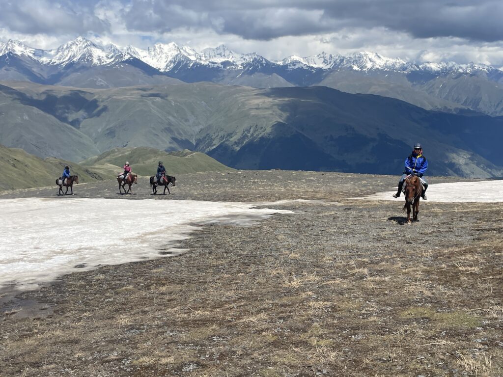Ruiters en paarden op een besneeuwde berg tijdens een trektocht in Georgië