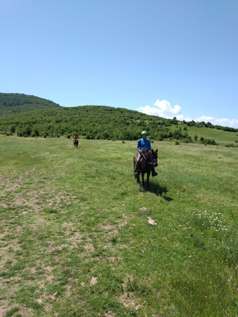 Ruiter en paard rijden door een veld tijdens een trektocht in Bulgarije