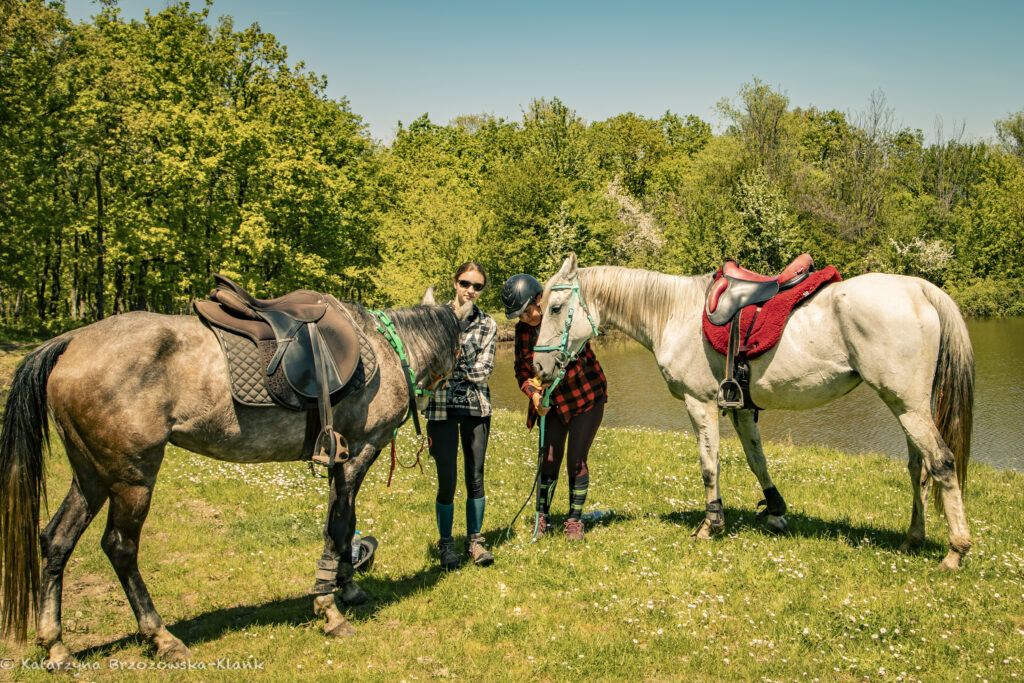 Twee vrouwen staan naast hun paarden tijdens een vakantie in Bulgarije